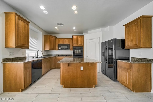 9792 Crescent Lodge Ct, Las Vegas, NV 89178 - kitchen featuring black appliances, a center island, dark stone counters, a sink, and a breakfast bar area