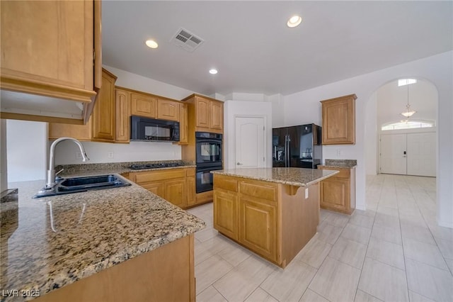 9792 Crescent Lodge Ct, Las Vegas, NV 89178 - kitchen featuring a sink, black appliances, light stone countertops, a kitchen island, and arched walkways