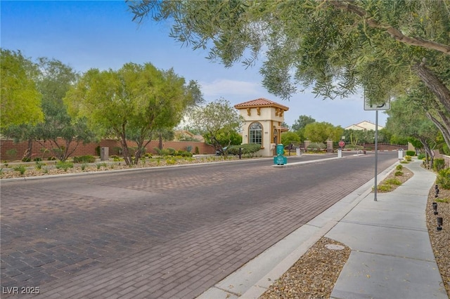 9792 Crescent Lodge Ct, Las Vegas, NV 89178 - view of decorative street with sidewalks, curbs, traffic signs, and a gated entry