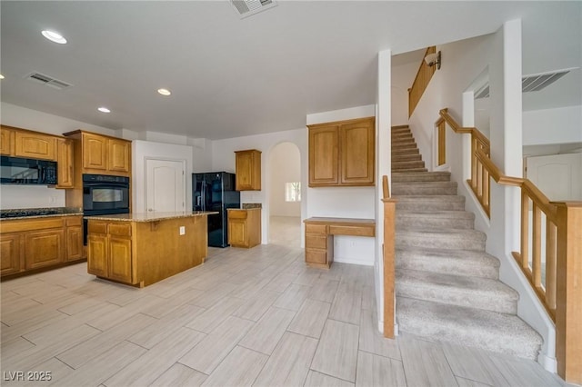 9792 Crescent Lodge Ct, Las Vegas, NV 89178 - kitchen featuring black appliances, a center island, brown cabinets, recessed lighting, and light stone countertops