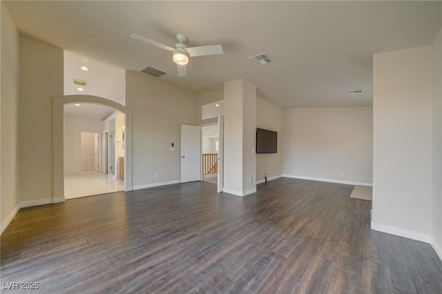 9792 Crescent Lodge Ct, Las Vegas, NV 89178 - unfurnished living room featuring ceiling fan, arched walkways, wood finished floors, and baseboards