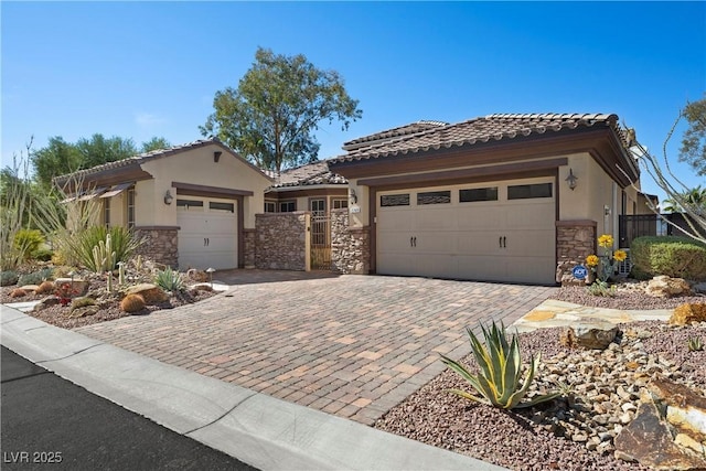 2749 Liberation Dr, Henderson, NV 89044 - view of front of house featuring stone siding, a garage, stucco siding, decorative driveway, and a tile roof