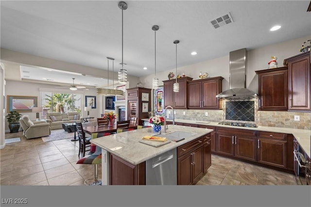 2749 Liberation Dr, Henderson, NV 89044 - kitchen featuring wall chimney exhaust hood, a sink, tasteful backsplash, appliances with stainless steel finishes, and ceiling fan