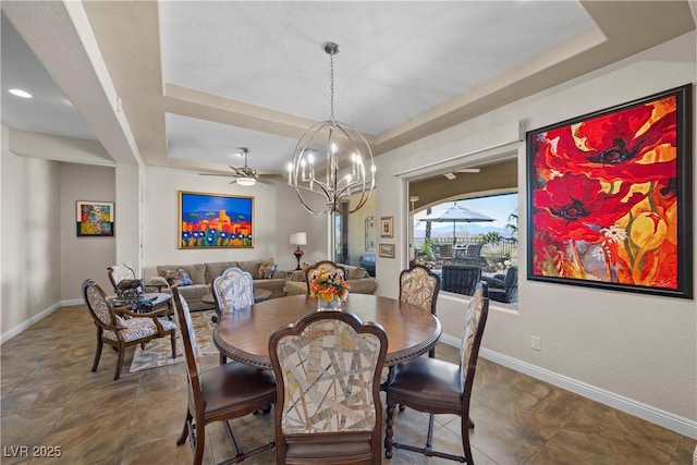 2749 Liberation Dr, Henderson, NV 89044 - dining space featuring a chandelier, a tray ceiling, baseboards, and ceiling fan