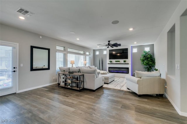 7077 Sunland Hills Ave, Las Vegas, NV 89113 - living room with ceiling fan, a glass covered fireplace, wood finished floors, recessed lighting, and baseboards