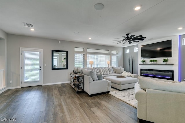 7077 Sunland Hills Ave, Las Vegas, NV 89113 - living room with a glass covered fireplace, healthy amount of natural light, wood finished floors, and recessed lighting
