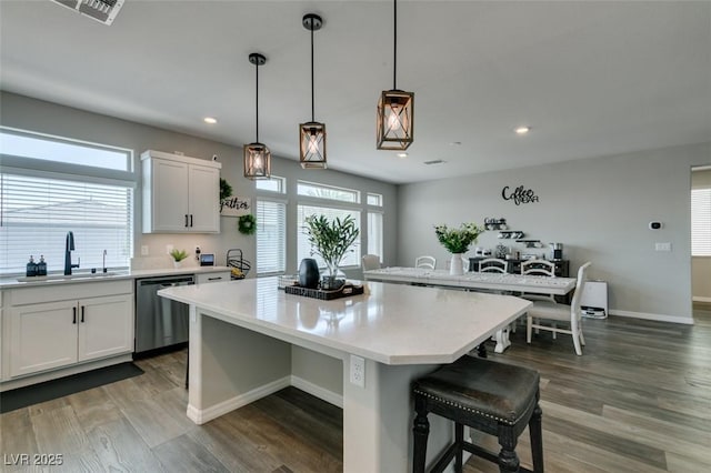 7077 Sunland Hills Ave, Las Vegas, NV 89113 - kitchen with dishwasher, a sink, a kitchen breakfast bar, light countertops, and recessed lighting