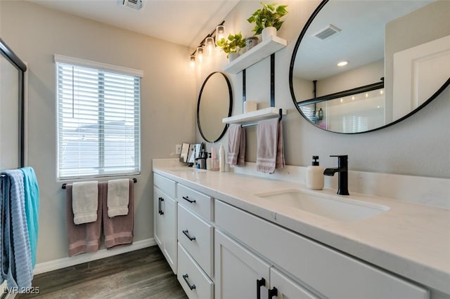 7077 Sunland Hills Ave, Las Vegas, NV 89113 - bathroom featuring double vanity, wood finished floors, baseboards, and a shower