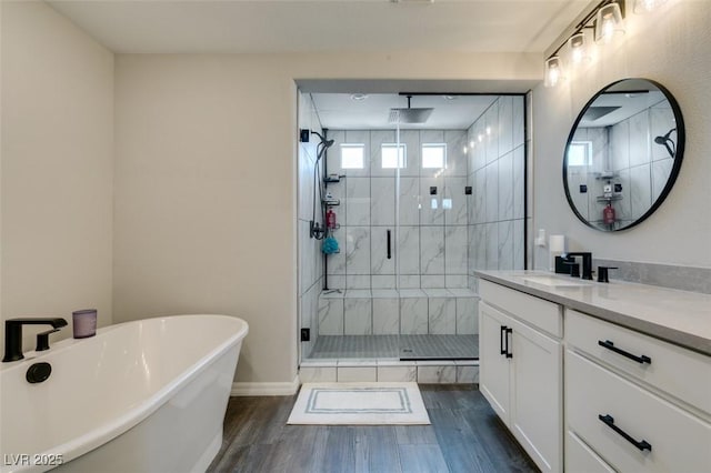 7077 Sunland Hills Ave, Las Vegas, NV 89113 - bathroom featuring vanity, a freestanding bath, a shower stall, wood finished floors, and baseboards