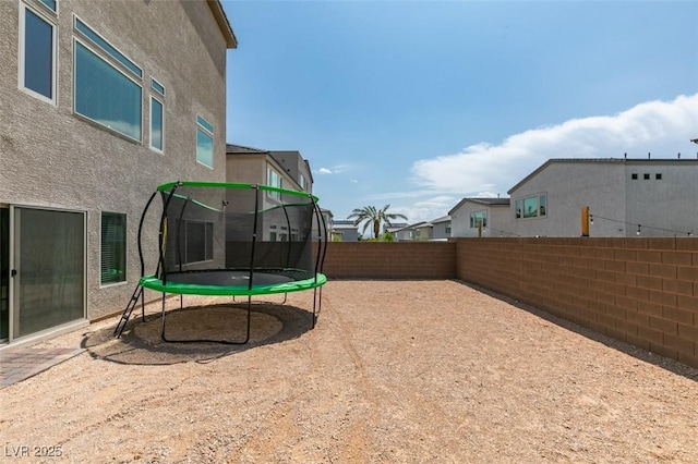 7077 Sunland Hills Ave, Las Vegas, NV 89113 - fenced backyard featuring a trampoline and a residential view
