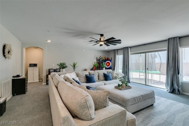7077 Sunland Hills Ave, Las Vegas, NV 89113 - living room with light colored carpet, arched walkways, a ceiling fan, recessed lighting, and baseboards