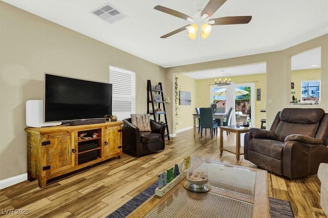 9236 Keystone Ridge Ave, Las Vegas, NV 89148 - living room with light wood-style flooring, a chandelier, a ceiling fan, and baseboards