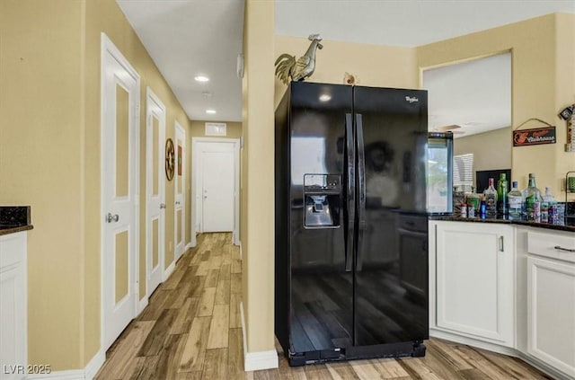 9236 Keystone Ridge Ave, Las Vegas, NV 89148 - kitchen featuring black fridge, white cabinets, light wood finished floors, recessed lighting, and dark stone countertops