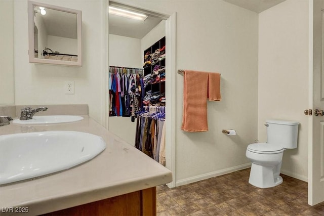 9236 Keystone Ridge Ave, Las Vegas, NV 89148 - bathroom with toilet, double vanity, baseboards, and a walk in closet