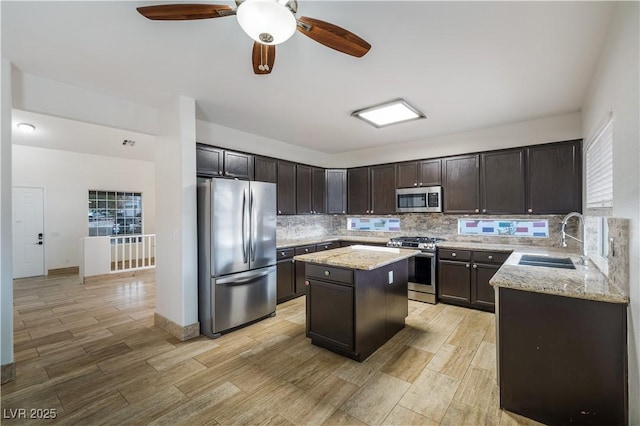 827 Happy Sparrow Ave, Henderson, NV 89052 - kitchen with stainless steel appliances, a sink, backsplash, and light stone countertops