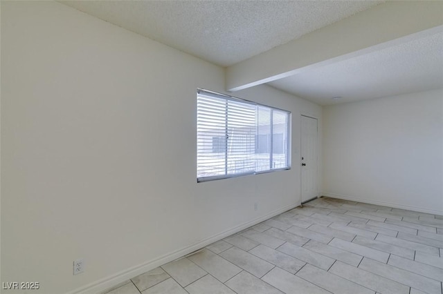 212 Orland St Unit 28, Las Vegas, NV 89107 - empty room with a textured ceiling, baseboards, and beamed ceiling