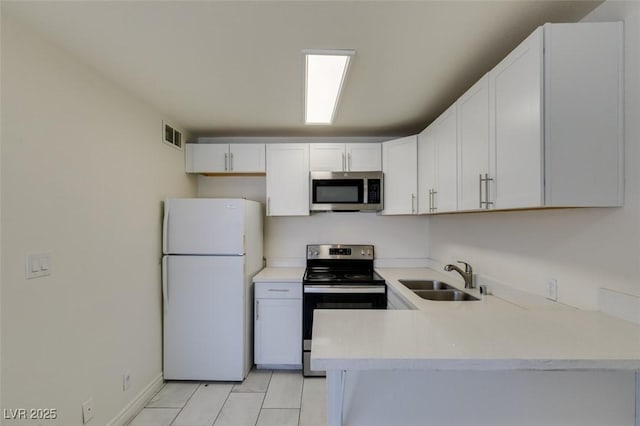 212 Orland St Unit 28, Las Vegas, NV 89107 - kitchen featuring stainless steel appliances, a sink, light countertops, light tile patterned flooring, and white cabinetry