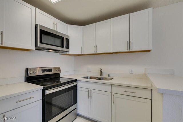 212 Orland St Unit 28, Las Vegas, NV 89107 - kitchen featuring appliances with stainless steel finishes, a sink, white cabinetry, and light countertops