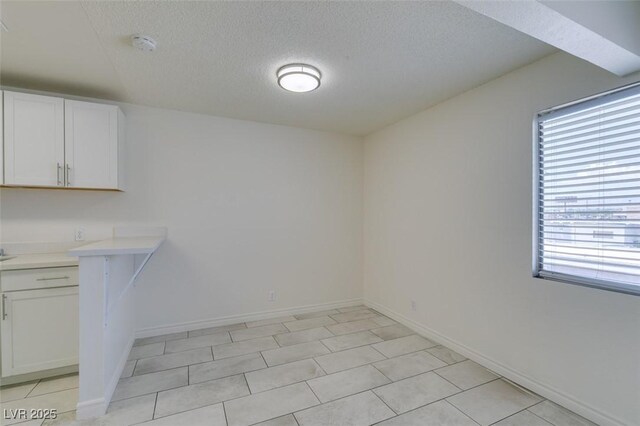 212 Orland St Unit 28, Las Vegas, NV 89107 - unfurnished dining area with a textured ceiling and baseboards
