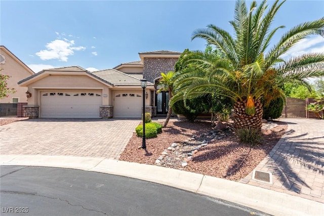 6779 Rainstorm Ridge Ave, Las Vegas, NV 89131 - view of front of property featuring an attached garage, decorative driveway, stone siding, stucco siding, and a tiled roof