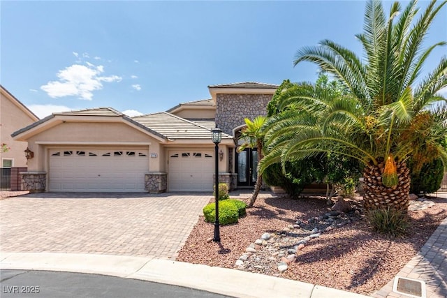 6779 Rainstorm Ridge Ave, Las Vegas, NV 89131 - view of front of house featuring stone siding, an attached garage, decorative driveway, and stucco siding