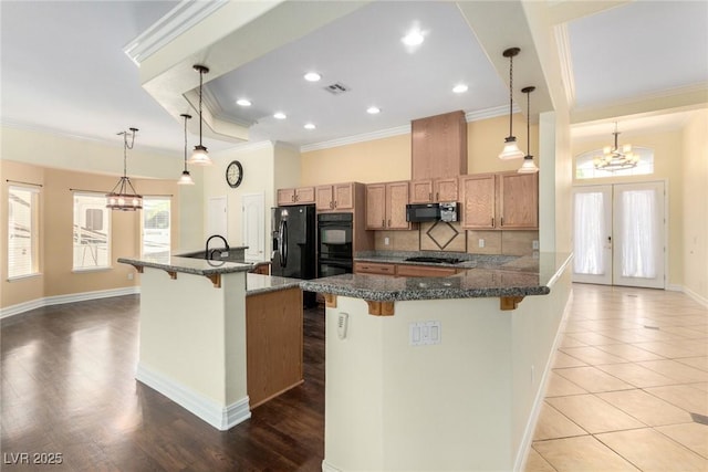 6779 Rainstorm Ridge Ave, Las Vegas, NV 89131 - kitchen featuring a kitchen breakfast bar, a chandelier, black appliances, ornamental molding, and tasteful backsplash