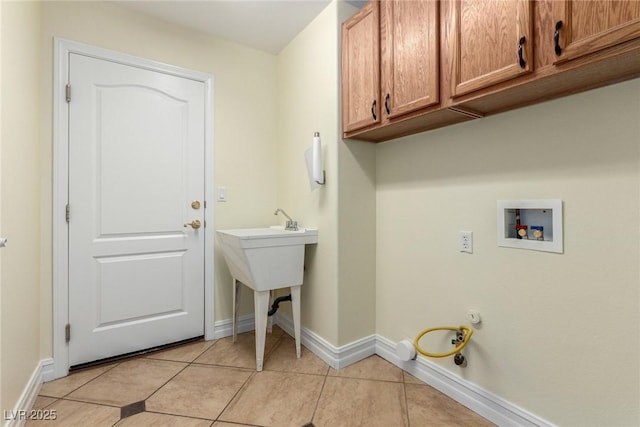 6779 Rainstorm Ridge Ave, Las Vegas, NV 89131 - laundry room with cabinet space, washer hookup, light tile patterned floors, and baseboards