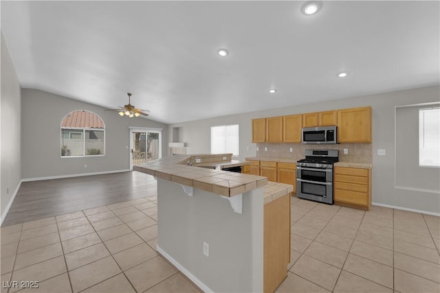 3228 Jumping Hills Ave, Henderson, NV 89052 - kitchen with appliances with stainless steel finishes, light tile patterned flooring, tile countertops, ceiling fan, and baseboards