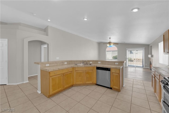 3228 Jumping Hills Ave, Henderson, NV 89052 - kitchen featuring appliances with stainless steel finishes, tile countertops, a ceiling fan, arched walkways, and vaulted ceiling