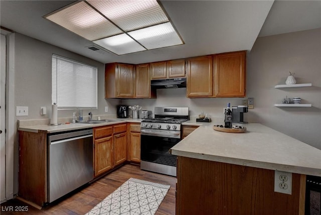 573 Sellers Pl, Henderson, NV 89011 - kitchen with stainless steel appliances, a sink, wood finished floors, range hood, and a peninsula
