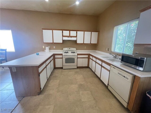 1667 Marion Bennet Dr, Las Vegas, NV 89106 - kitchen with white appliances, a sink, a peninsula, under cabinet range hood, and light countertops