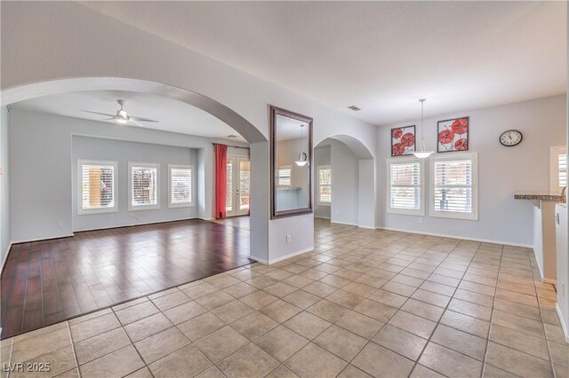 7427 Page Ranch Ct, Las Vegas, NV 89131 - unfurnished living room featuring ceiling fan, light tile patterned floors, healthy amount of natural light, and baseboards