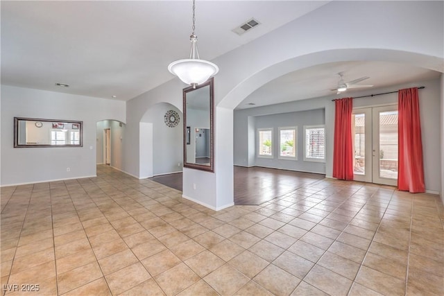 7427 Page Ranch Ct, Las Vegas, NV 89131 - unfurnished living room featuring light tile patterned floors, a ceiling fan, arched walkways, and baseboards