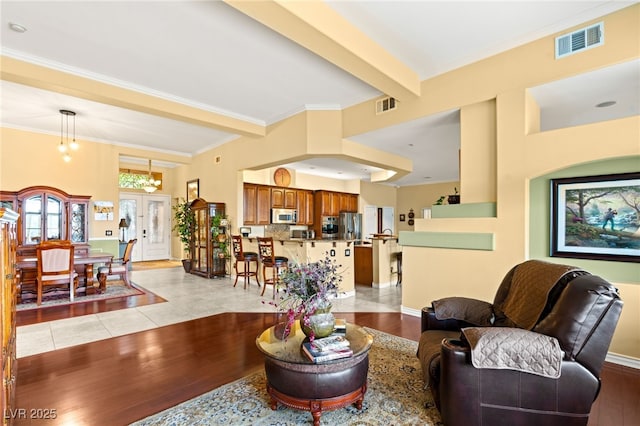 5940 Vizzi Ct, Las Vegas, NV 89131 - living area featuring light wood-type flooring, ornamental molding, beamed ceiling, and french doors