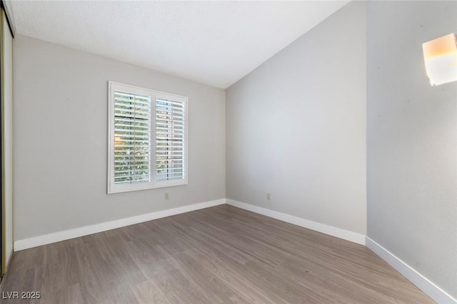 3157 Capetown Way, Las Vegas, NV 89128 - unfurnished room featuring wood finished floors, baseboards, and lofted ceiling
