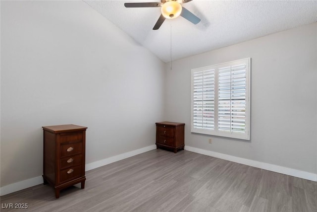 3157 Capetown Way, Las Vegas, NV 89128 - spare room with light wood-style floors, a ceiling fan, baseboards, lofted ceiling, and a textured ceiling