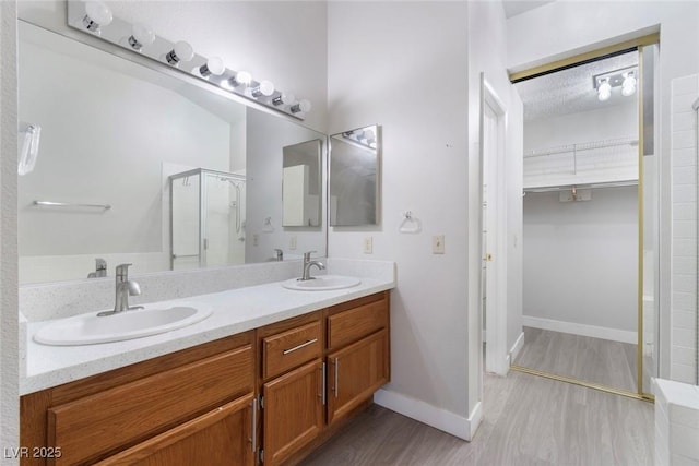 3157 Capetown Way, Las Vegas, NV 89128 - full bath with a stall shower, double vanity, a walk in closet, wood finished floors, and baseboards