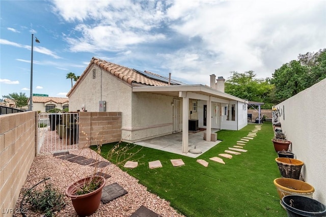 3157 Capetown Way, Las Vegas, NV 89128 - back of house featuring a gate, a patio area, stucco siding, a tiled roof, and a chimney