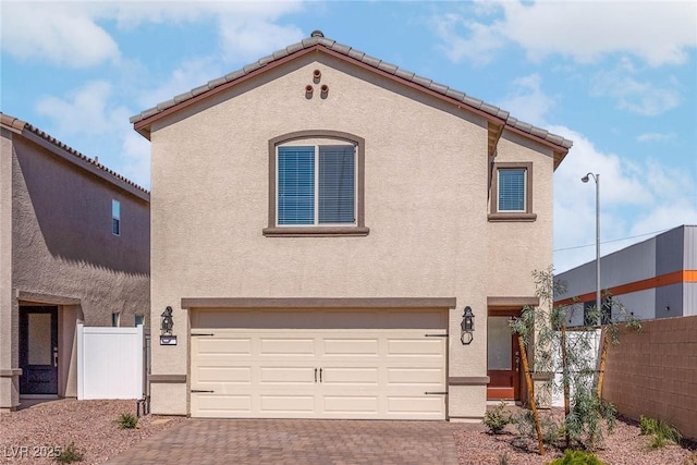 6197 Blood Lily Ave, Las Vegas, NV 89122 - view of front of home featuring an attached garage, decorative driveway, stucco siding, and a tiled roof