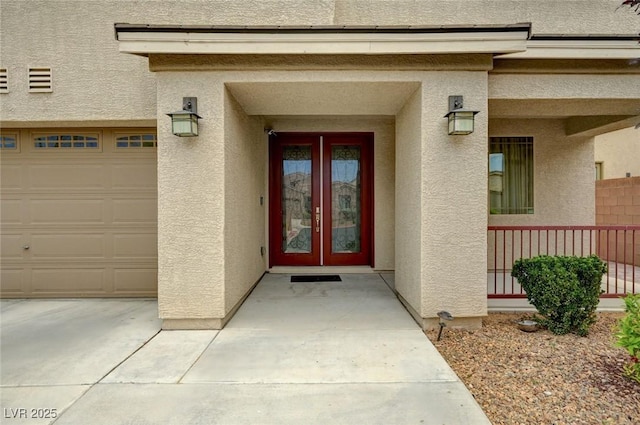 8223 Saddleback Ledge Ave, Las Vegas, NV 89147 - view of exterior entry featuring stucco siding, an attached garage, and french doors