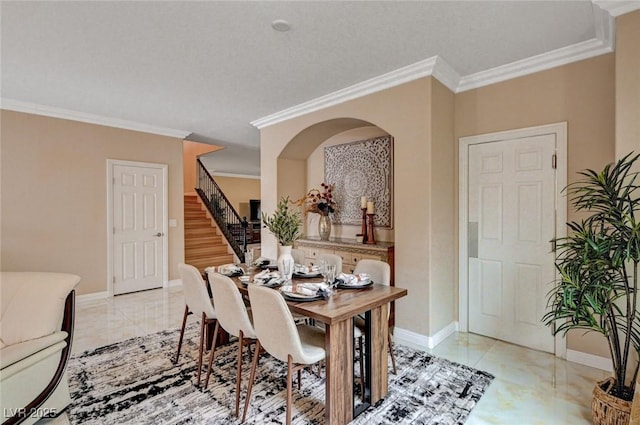 8223 Saddleback Ledge Ave, Las Vegas, NV 89147 - dining room with stairway, crown molding, baseboards, and arched walkways