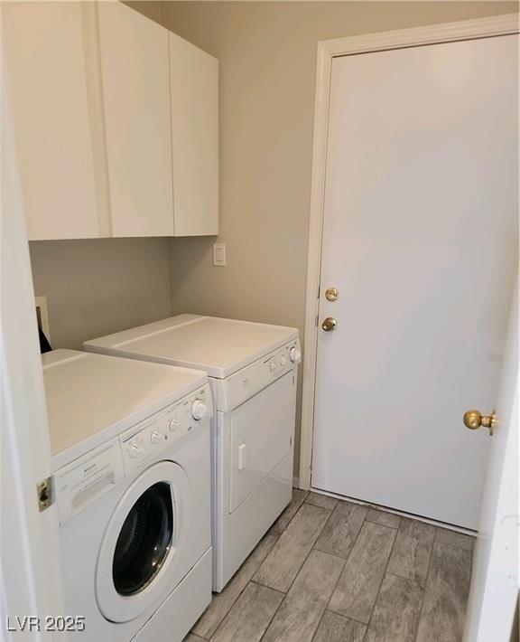 4718 Victoria Garden Ave, North Las Vegas, NV 89031 - washroom featuring washing machine and clothes dryer, cabinet space, and wood tiled floors