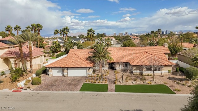 3236 Cliff Sieler Ct, Las Vegas, NV 89117 - view of front of home with an attached garage, a tiled roof, driveway, stucco siding, and a residential view