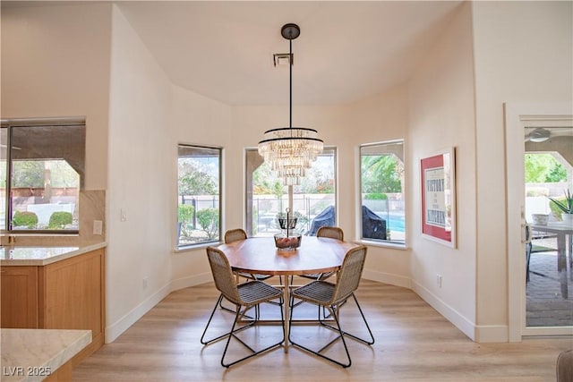 3236 Cliff Sieler Ct, Las Vegas, NV 89117 - dining area featuring a chandelier, light wood-style floors, and baseboards