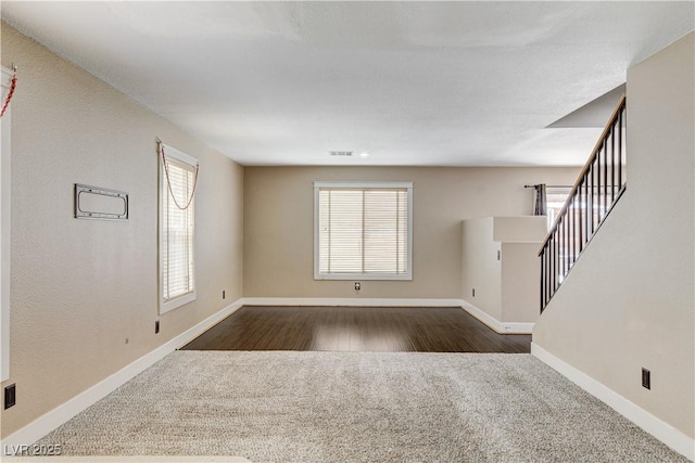 3717 Shanagolden St, Las Vegas, NV 89129 - unfurnished living room featuring dark carpet, baseboards, and stairs