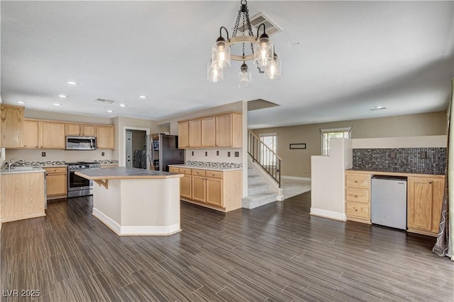 3717 Shanagolden St, Las Vegas, NV 89129 - kitchen featuring stainless steel appliances, light brown cabinets, baseboards, a chandelier, and a sink