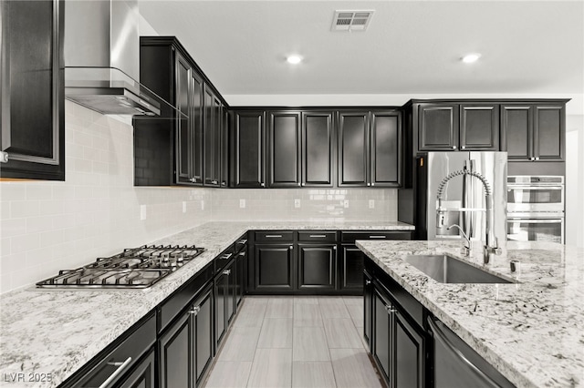767 Tallgrass St, Las Vegas, NV 89138 - kitchen featuring dark cabinetry, stainless steel appliances, a sink, light stone counters, and recessed lighting