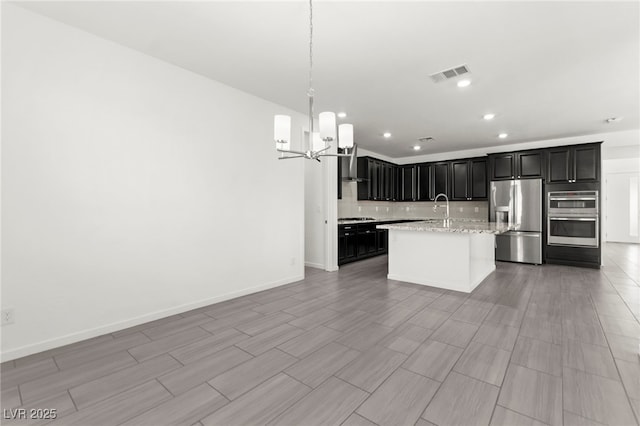 767 Tallgrass St, Las Vegas, NV 89138 - kitchen with appliances with stainless steel finishes, a chandelier, recessed lighting, decorative backsplash, and an island with sink