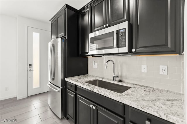 767 Tallgrass St, Las Vegas, NV 89138 - kitchen with appliances with stainless steel finishes, a sink, dark cabinets, and tasteful backsplash