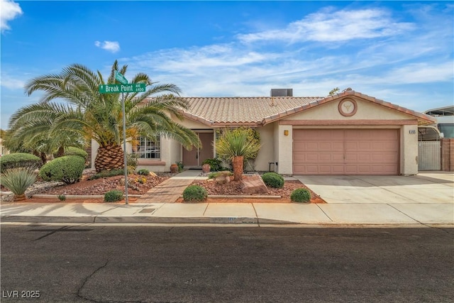 6405 Break Point Ave, Las Vegas, NV 89130 - view of front of house with a tiled roof, stucco siding, an attached garage, and driveway